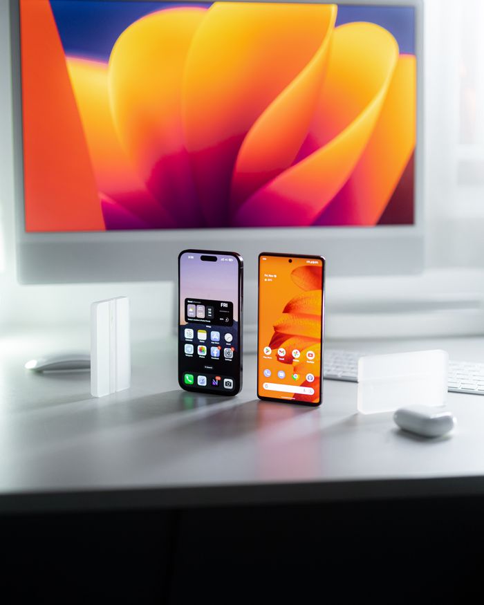 Home Two smartphones on a desk with a vibrant, abstract screen background and ample copy space.