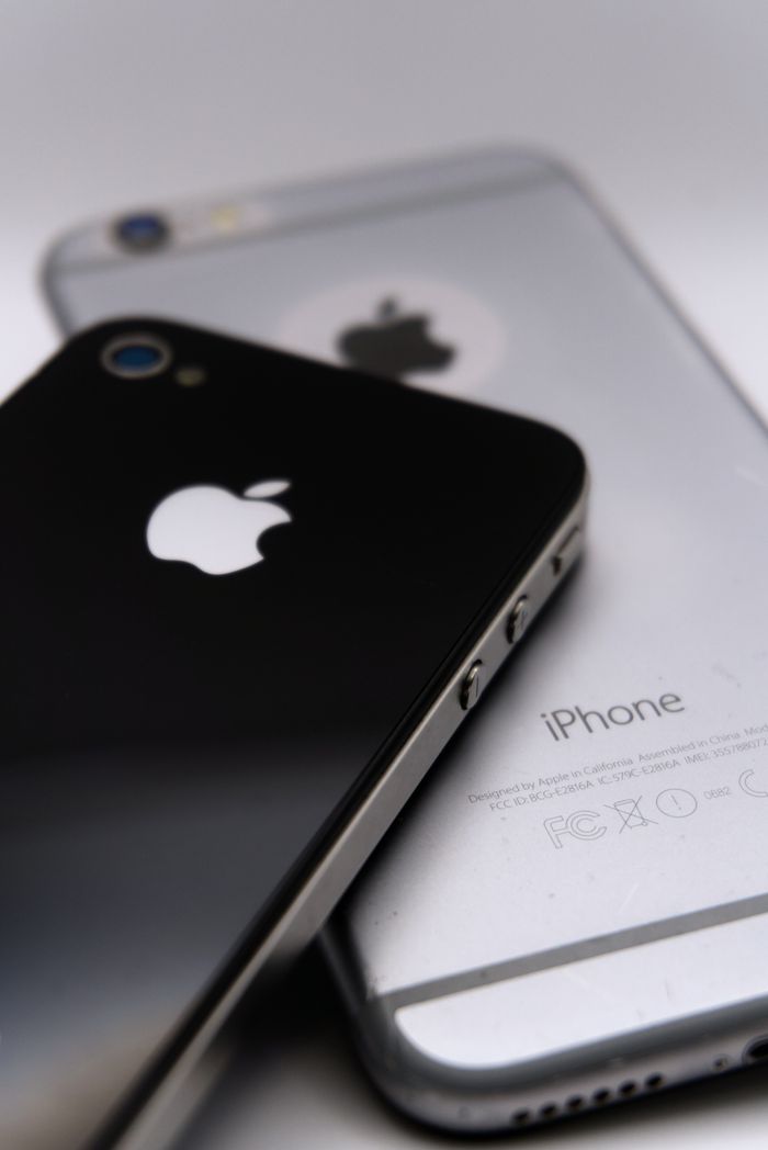 Home Detailed shot of two smartphones featuring the Apple logo, showcasing modern technology design.